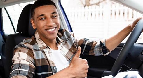 Man smiles in car