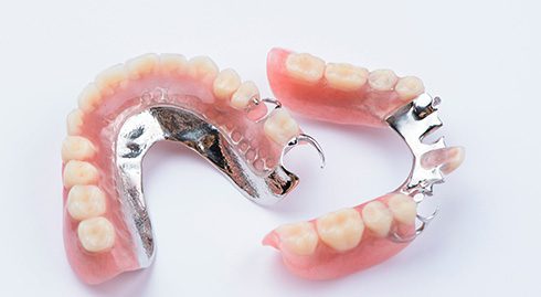 Full and partial dentures arranged in a circle on a white background