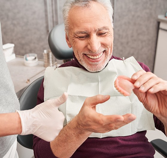 Transparent illustration showing how dentures attach to implants in a lower arch with white background