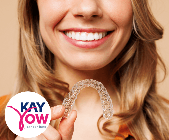 Woman in white shirt holding clear aligner